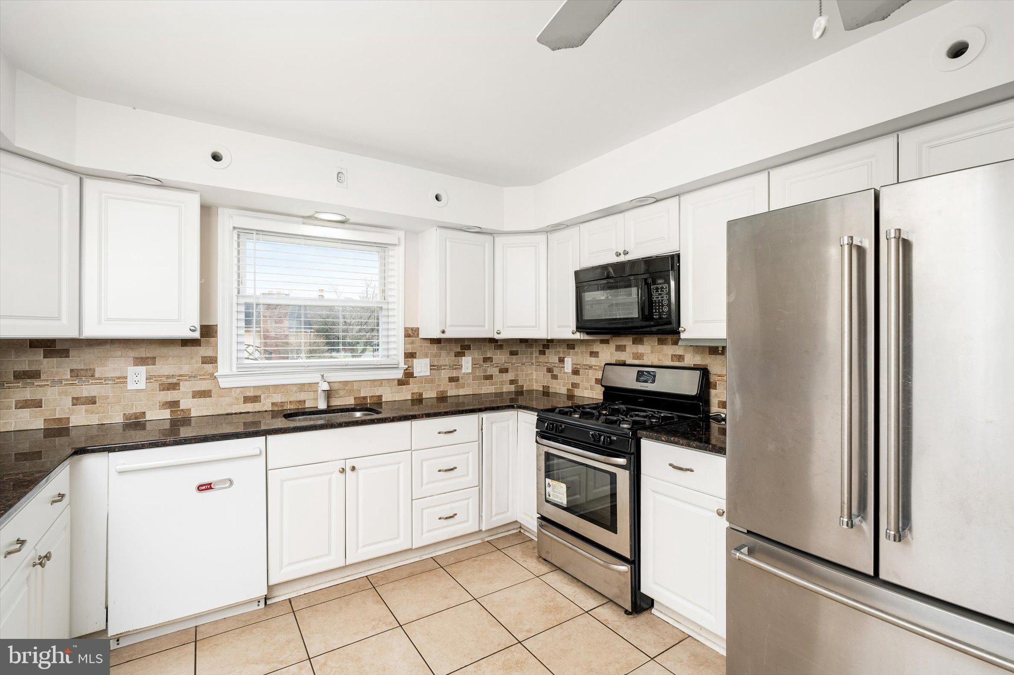 446 Trinity Avenue Hamilton, NJ 08619 - Photo 4 of 31 a kitchen with white cabinets sink and stainless steel appliances