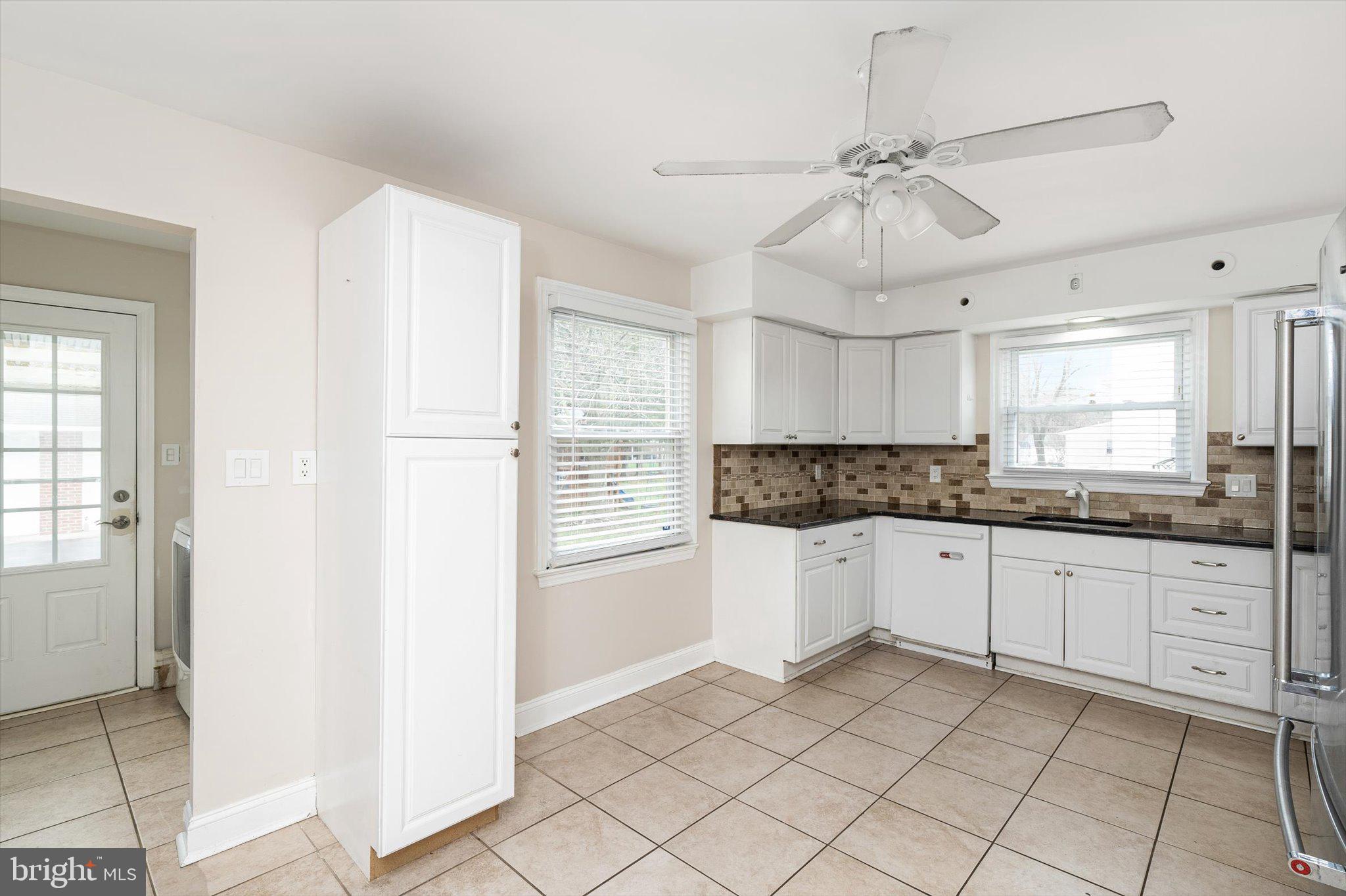 446 Trinity Avenue Hamilton, NJ 08619 - Photo 6 of 31 a kitchen with granite countertop white cabinets a sink a window and stainless steel appliances