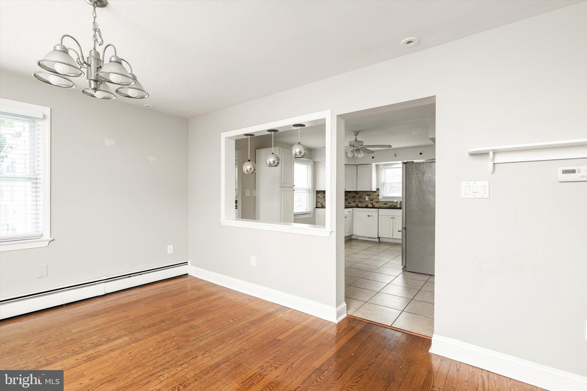 446 Trinity Avenue Hamilton, NJ 08619 - Photo 10 of 31 a view of a big room with wooden floor a chandelier and a kitchen