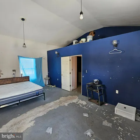 a spacious bedroom with a bed and a chandelier