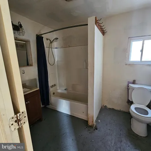 a bathroom with a tub and a toilet