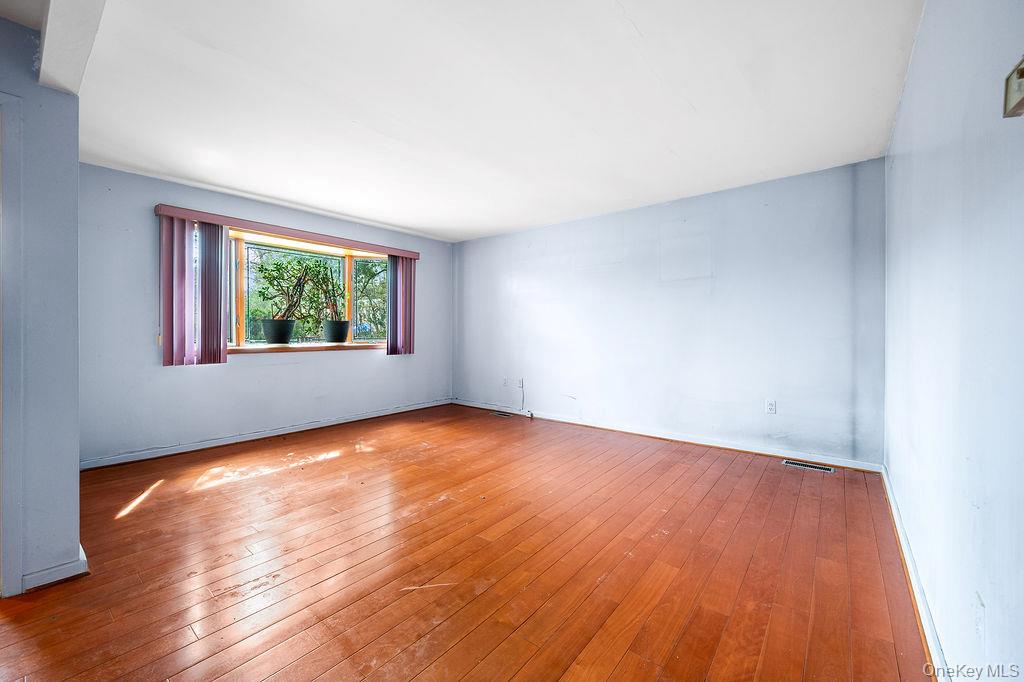 11 Valley View Road Great Neck, NY 11021 - Photo 10 of 19 an empty room with wooden floor and windows
