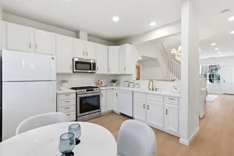 a kitchen with granite countertop a sink stove and refrigerator