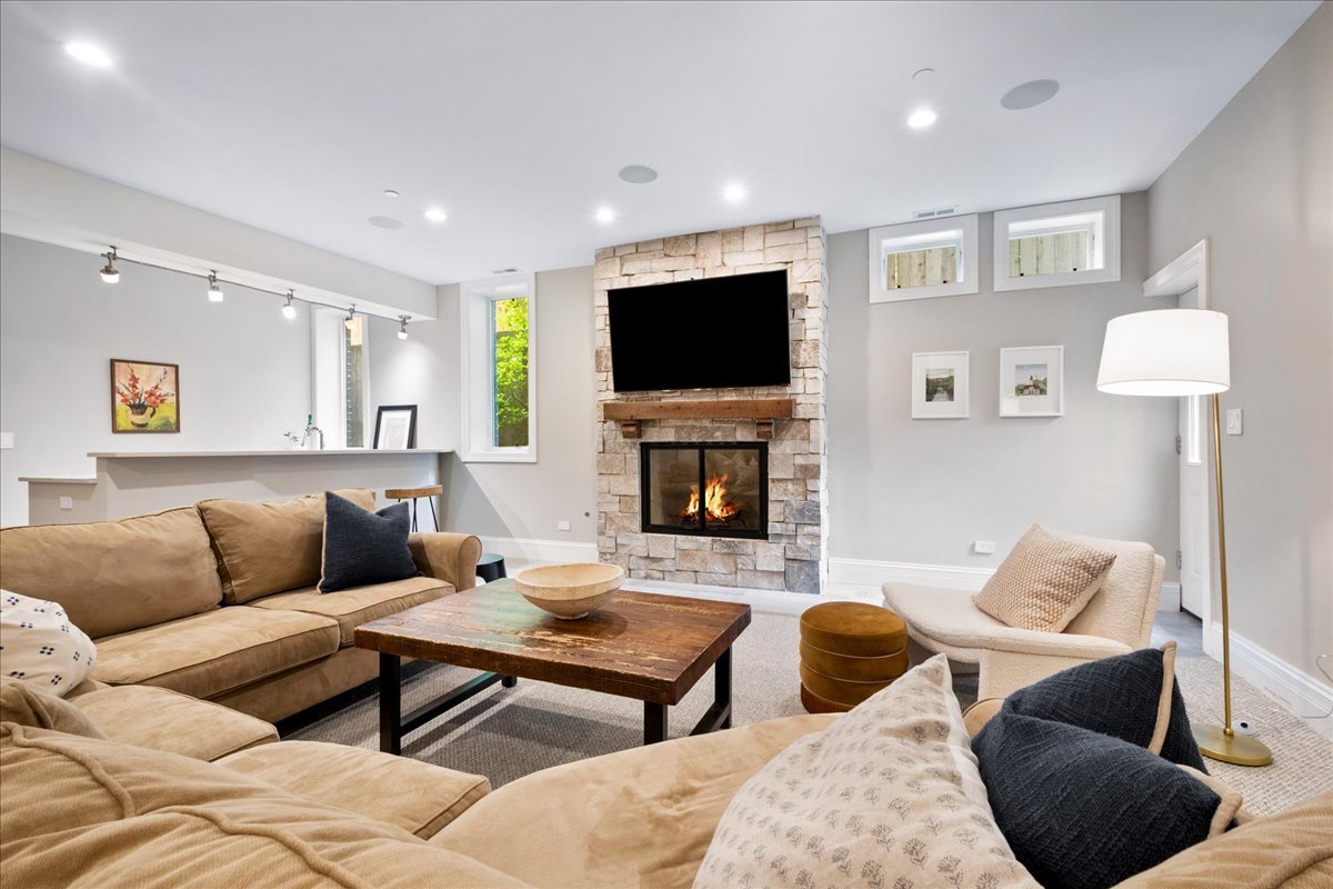 2921 Simpson Street Evanston, IL 60201 - Photo 27 of 41 a living room with furniture a flat screen tv and a fireplace