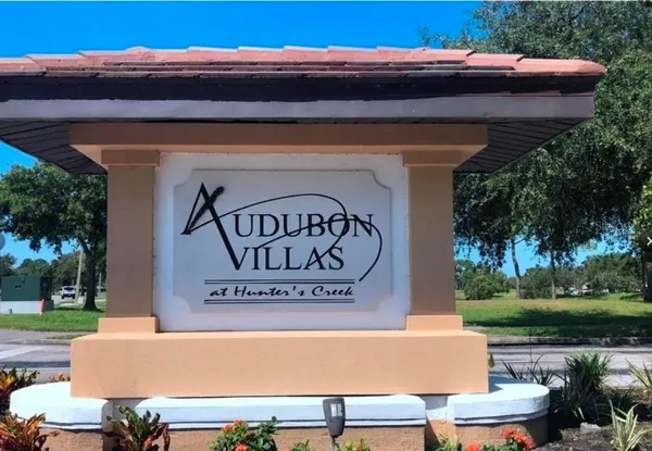 a view of a sign on a sidewalk next to a yard