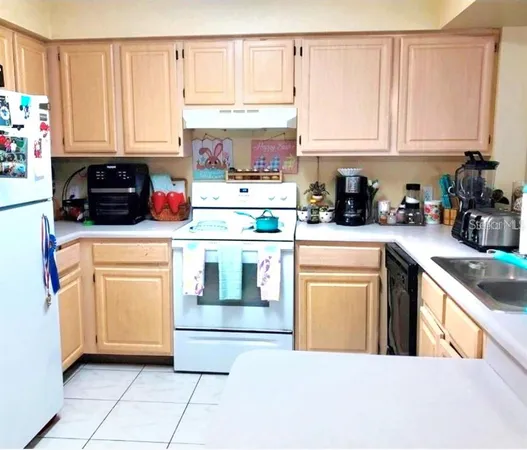 a kitchen with stainless steel appliances granite countertop a stove a sink and white cabinets