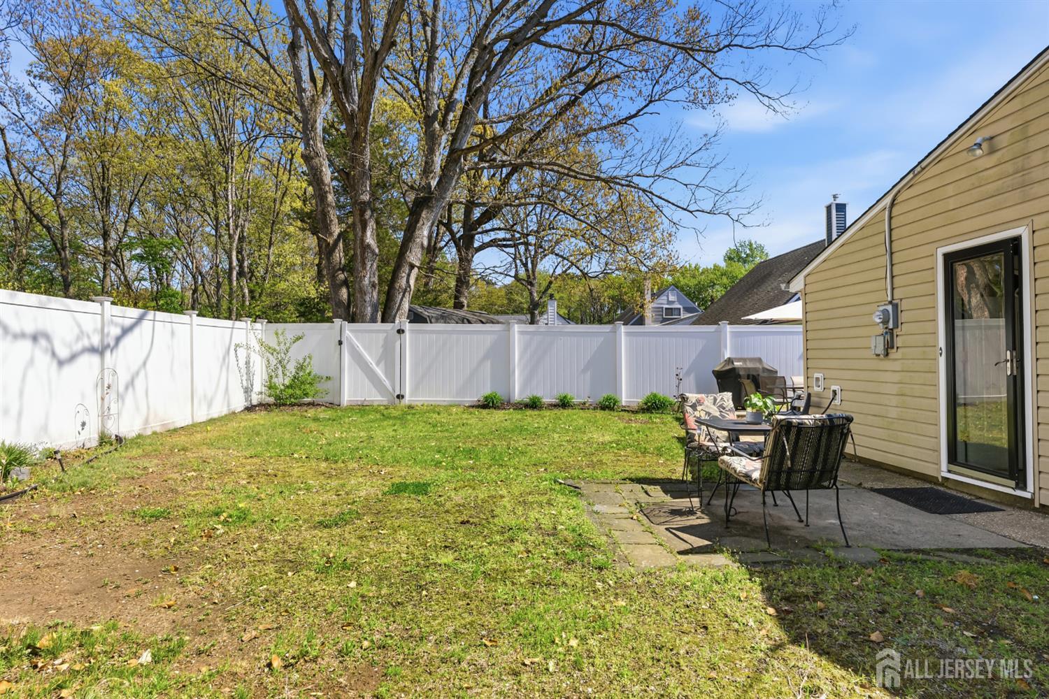 14 Sunrise Road Old Bridge, NJ 08857 - Photo 12 of 32 a view of a backyard with table and chairs and wooden fence