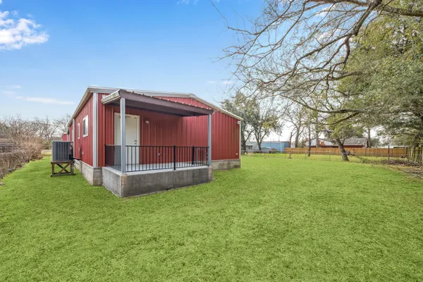 a backyard of a house with table and sofas