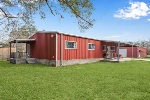 a view of house with yard outdoor seating and green field