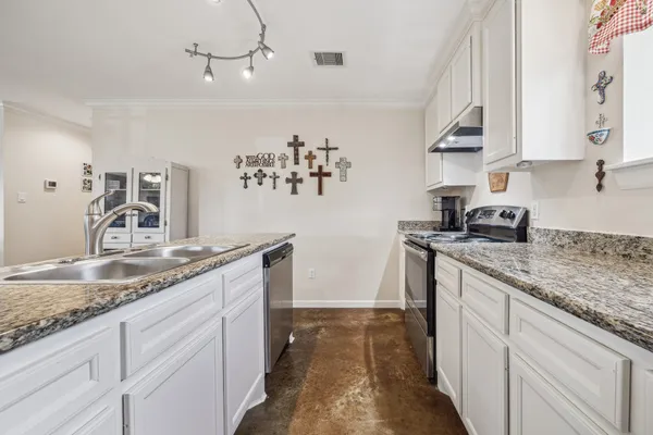 a kitchen with granite countertop a sink stainless steel appliances and cabinets