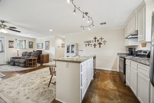 a kitchen with furniture a counter top space a sink stainless steel appliances and cabinets