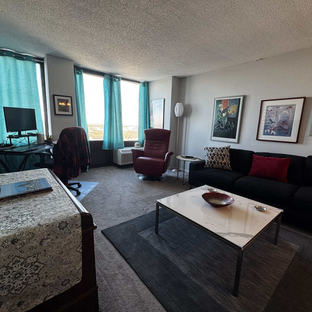 5320 North Sheridan Road, Unit 2001 Chicago, IL 60640 - Photo 4 of 14 a living room with furniture and a flat screen tv