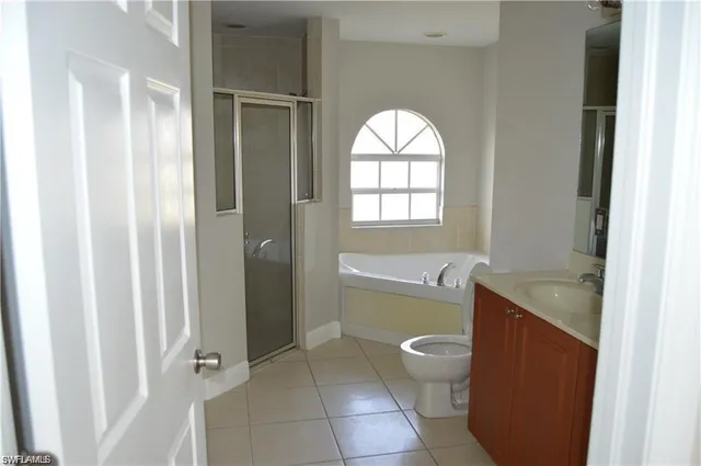 a bathroom with a granite countertop sink a toilet and shower