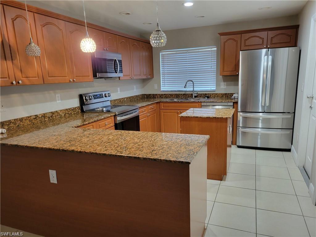 4209 30th Street Southwest Lehigh Acres, FL 33976 - Photo 8 of 13 a kitchen with stainless steel appliances granite countertop a sink a stove a refrigerator a washer and dryer
