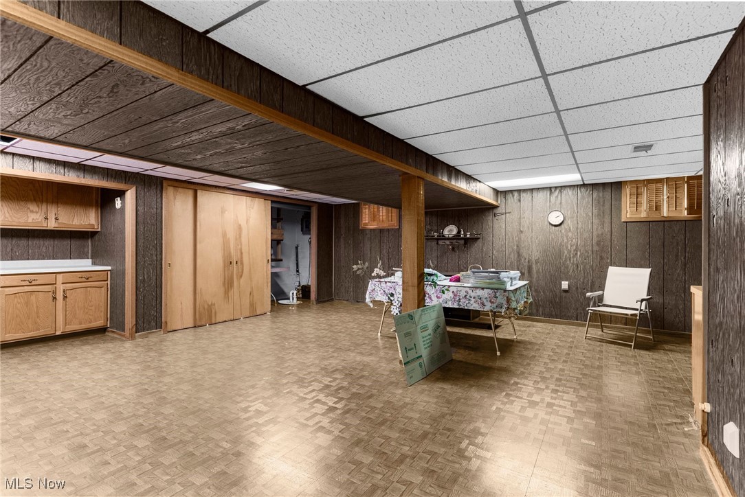 1295 Shields Road Youngstown, OH 44511 - Photo 18 of 27 Finished basement featuring wooden walls and a drop ceiling