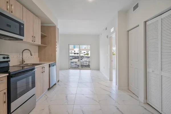 a large kitchen with cabinets and wooden floor