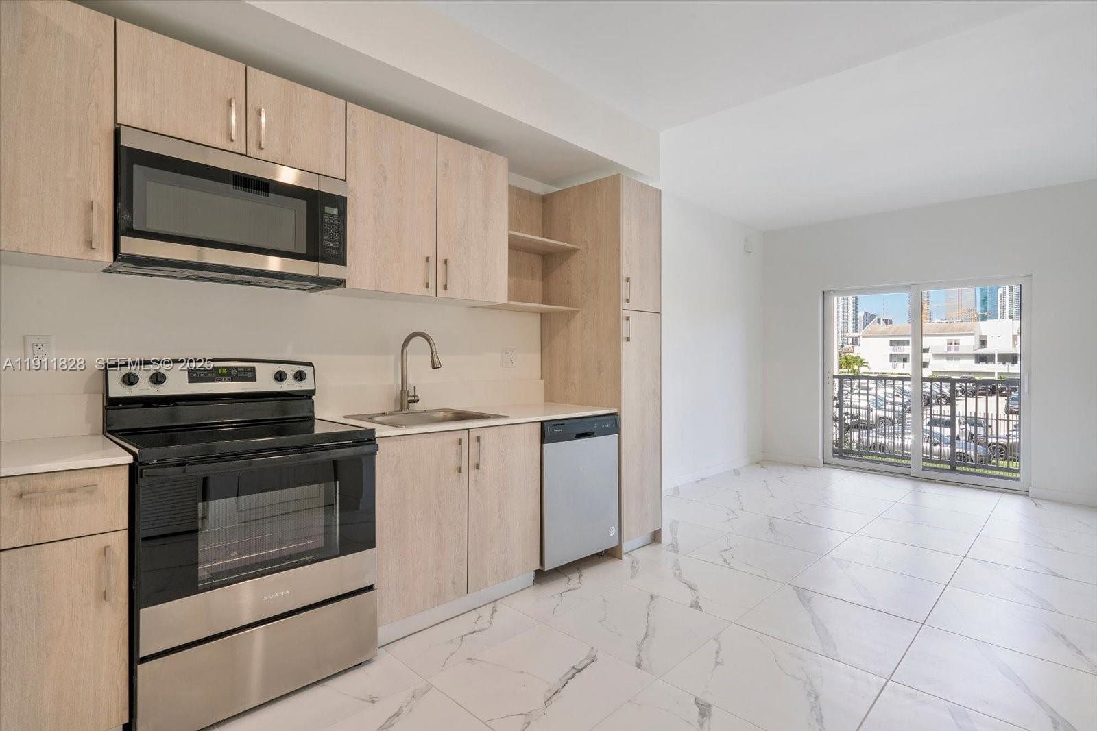 420 Southwest 7th Avenue, Unit 203 Miami, FL 33130 - Photo 3 of 15 a kitchen with stainless steel appliances granite countertop a stove microwave and sink