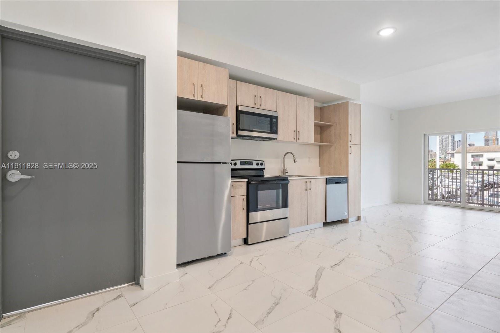 420 Southwest 7th Avenue, Unit 203 Miami, FL 33130 - Photo 4 of 15 a kitchen with stainless steel appliances a refrigerator and a stove top oven