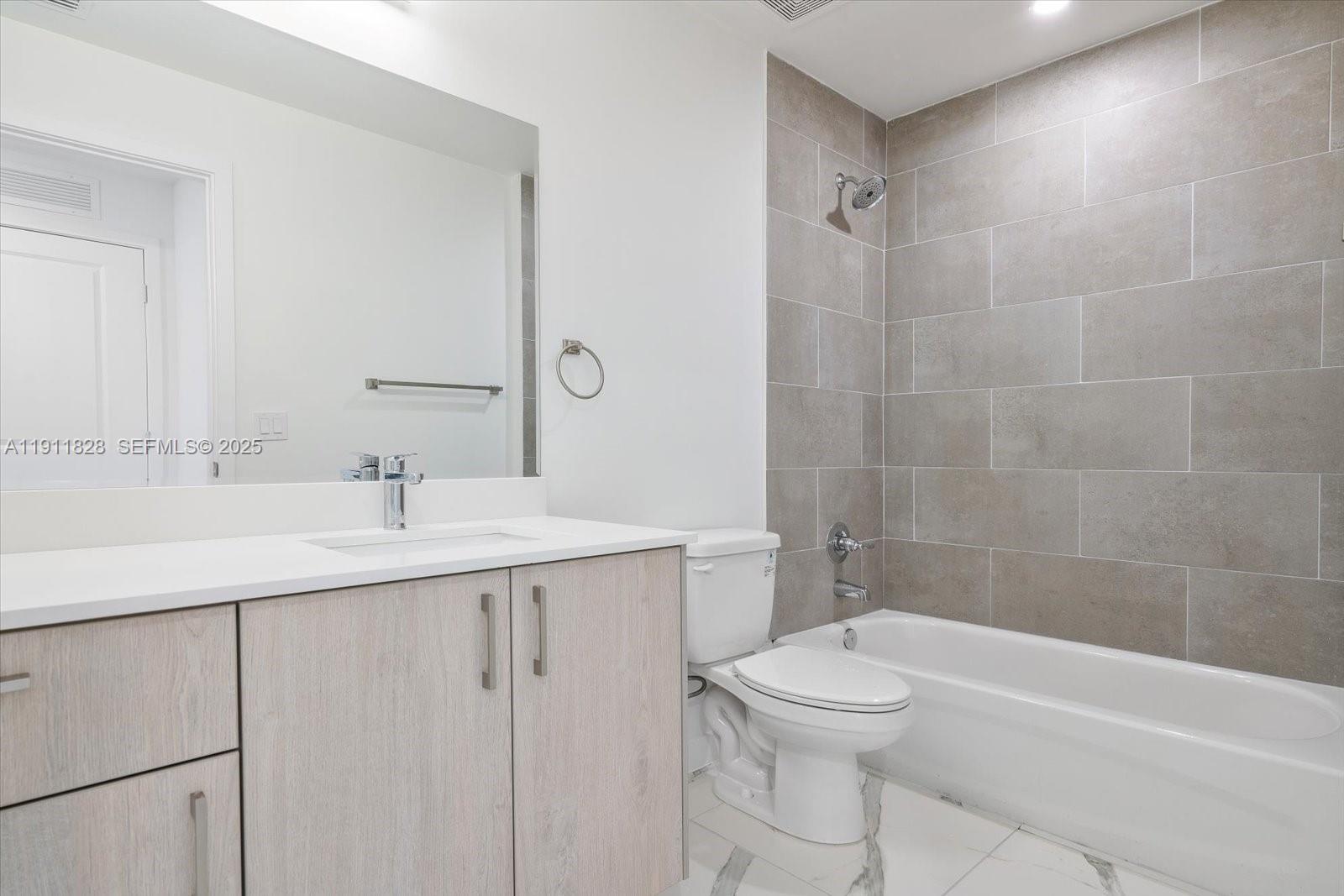420 Southwest 7th Avenue, Unit 203 Miami, FL 33130 - Photo 10 of 15 a bathroom with a toilet a sink a mirror and bathtub