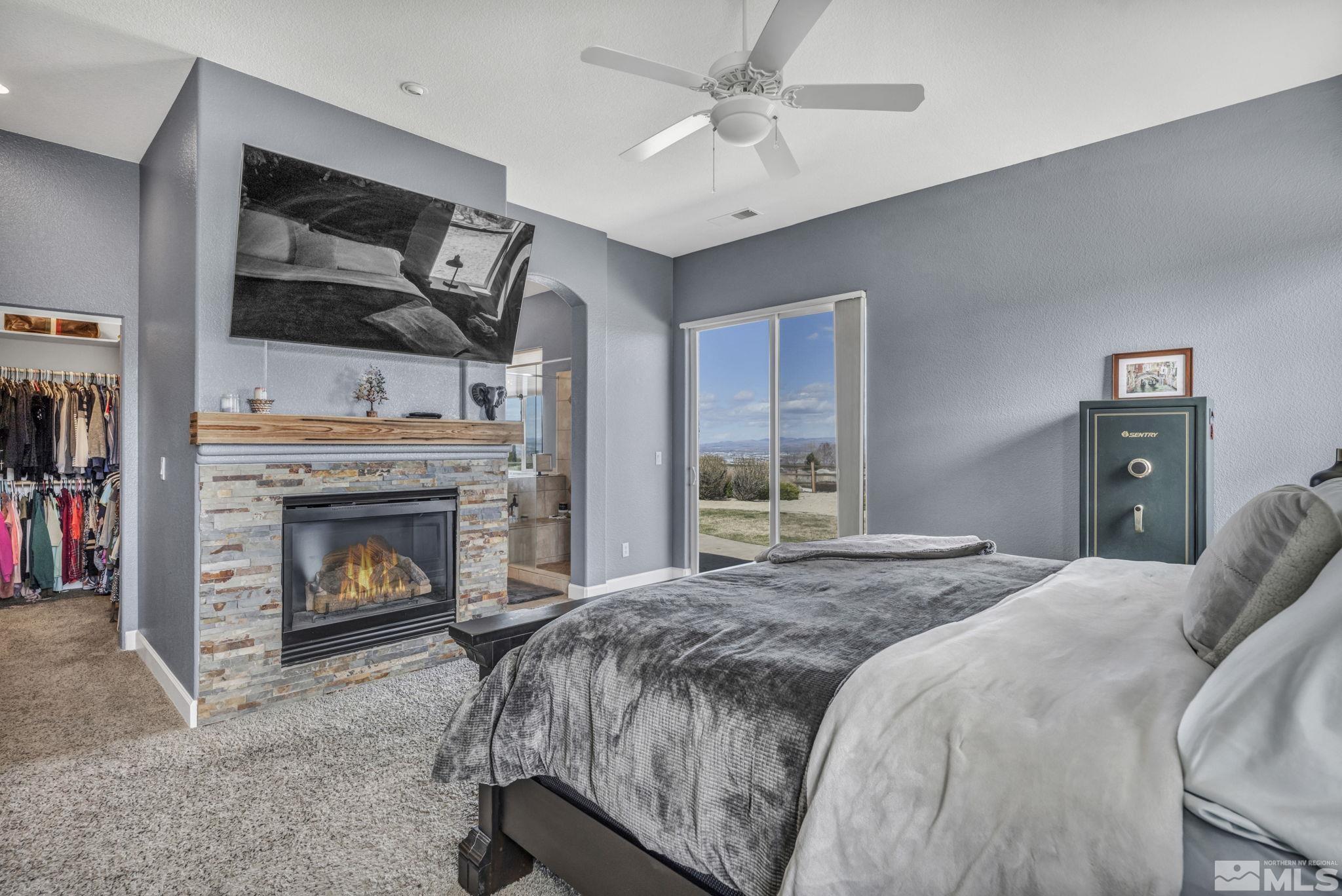 5544 New Mexico Court Reno, NV 89511 - Photo 22 of 39 a spacious bedroom with a bed and a fireplace
