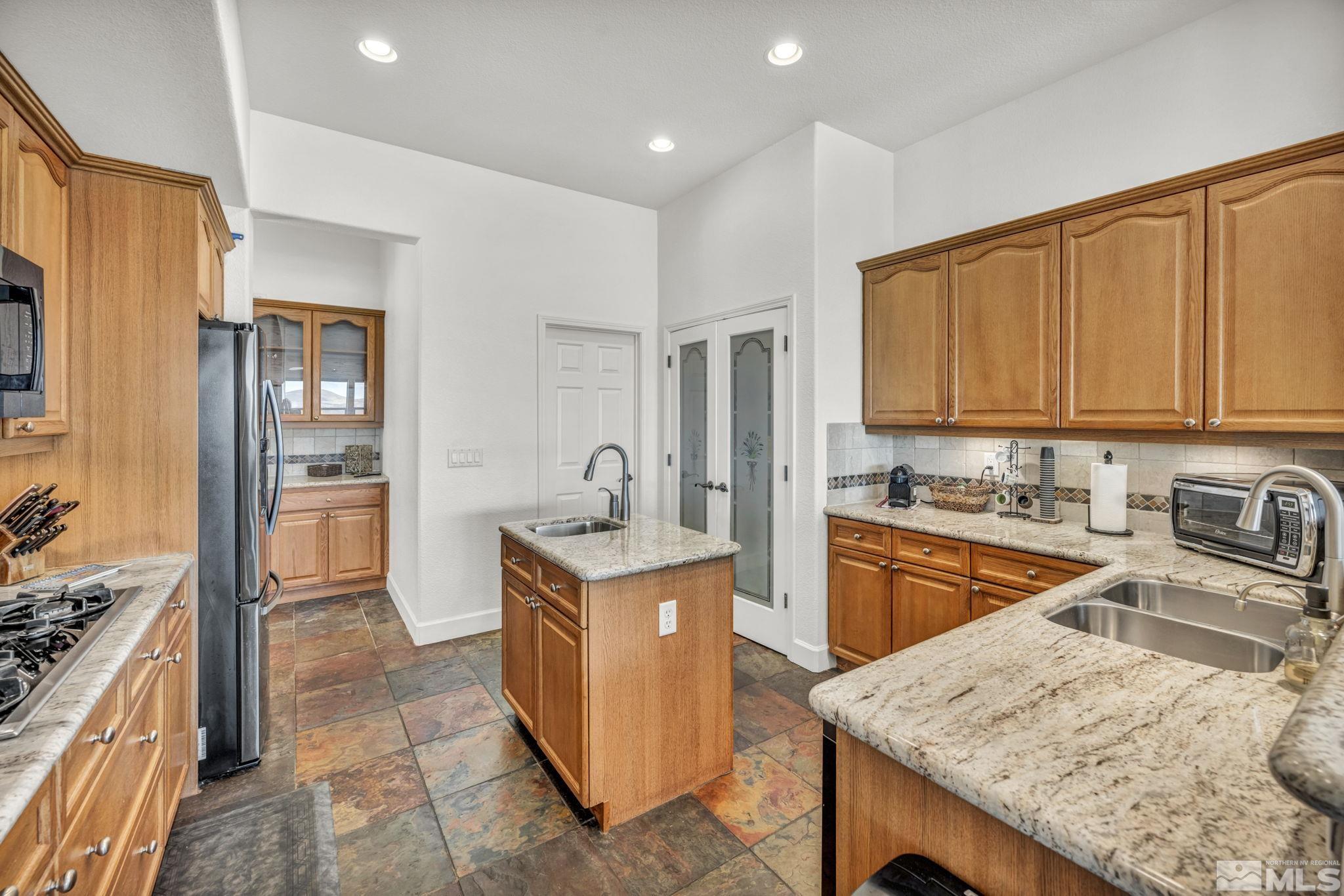 5544 New Mexico Court Reno, NV 89511 - Photo 3 of 39 a kitchen with stainless steel appliances granite countertop a sink stove refrigerator and cabinets