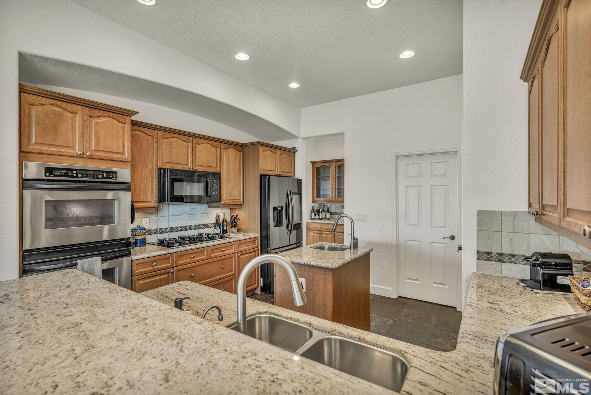 5544 New Mexico Court Reno, NV 89511 - Photo 4 of 39 a kitchen with stainless steel appliances granite countertop a sink stove and refrigerator