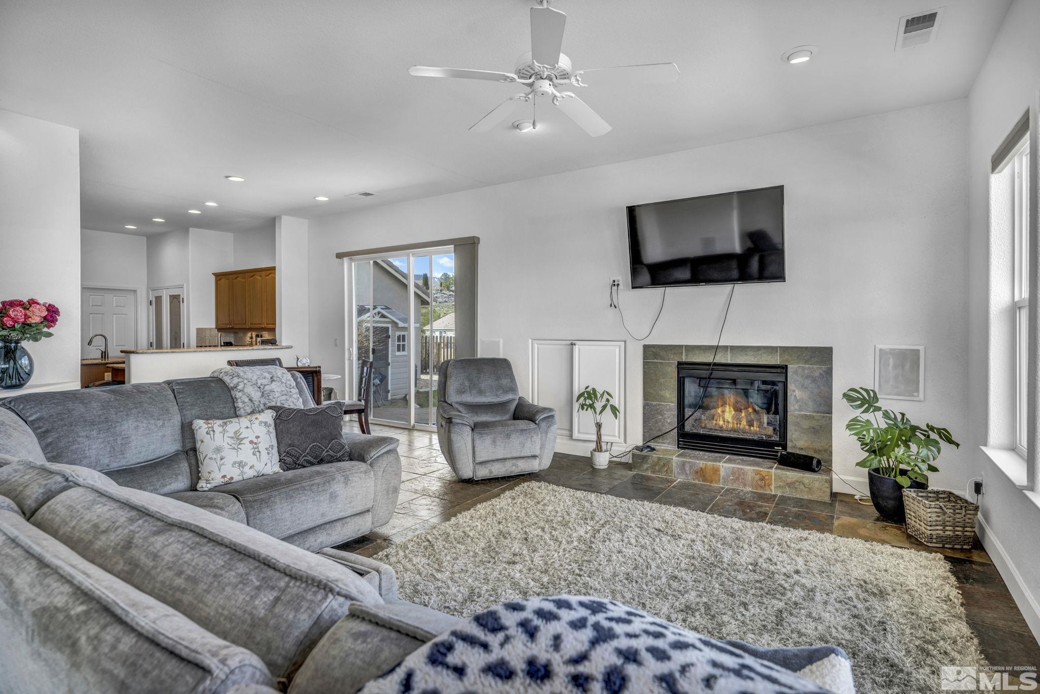 5544 New Mexico Court Reno, NV 89511 - Photo 9 of 39 a living room with furniture a flat screen tv and a fireplace