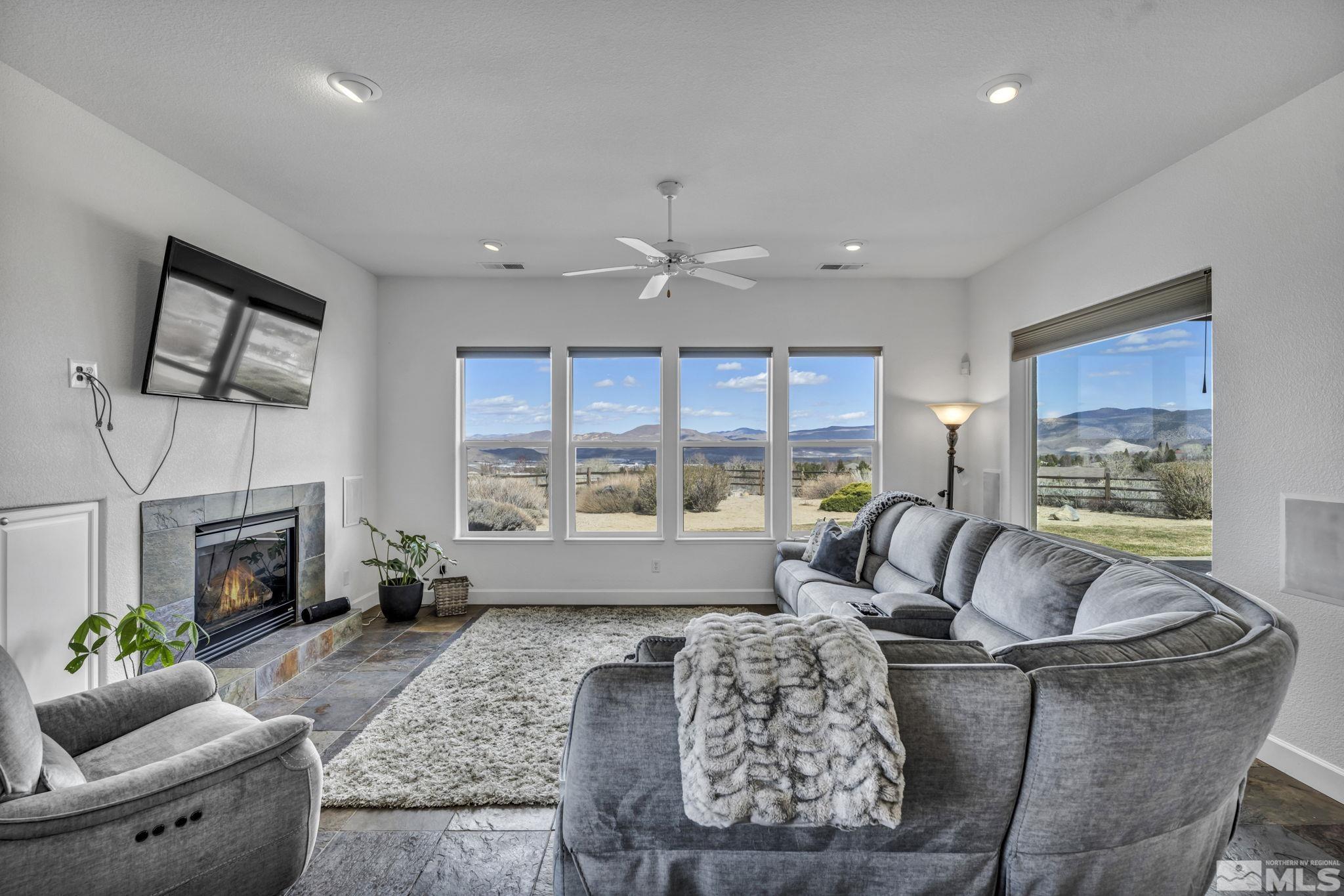 5544 New Mexico Court Reno, NV 89511 - Photo 10 of 39 a living room with furniture a fireplace and a floor to ceiling window