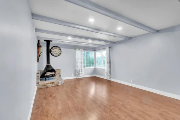 a view of a room with wooden floor and a window