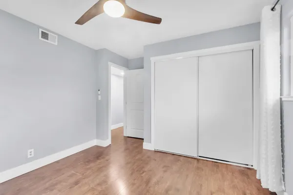 a view of an empty room with wooden floor