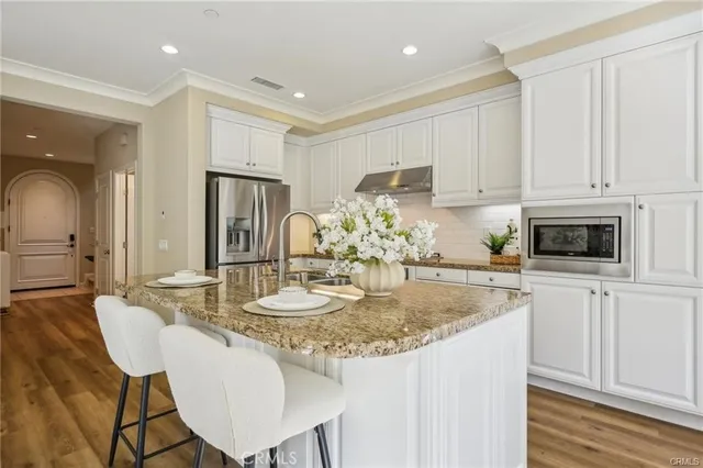 a kitchen with kitchen island granite countertop a white cabinets and chairs