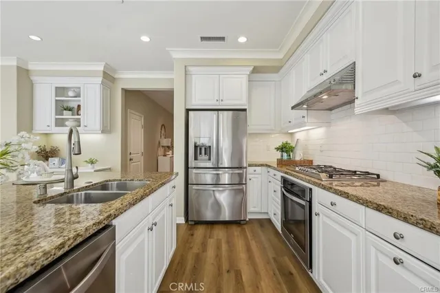a kitchen with stainless steel appliances granite countertop a sink stove and refrigerator