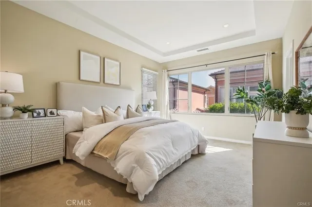 a spacious bedroom with a bed and a potted plant