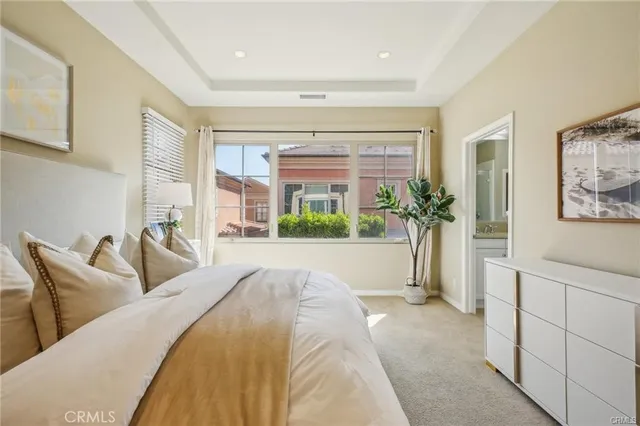 a spacious bedroom with a large bed and a potted plant