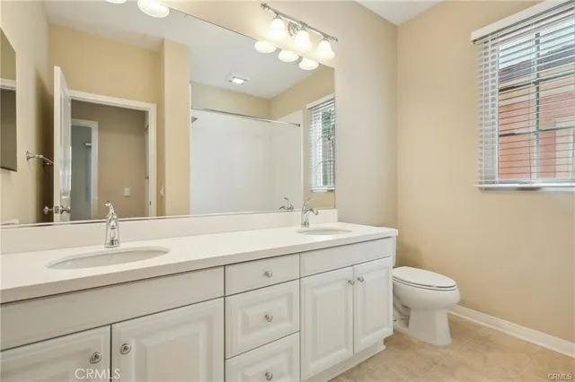 a bathroom with a toilet a sink a and mirror