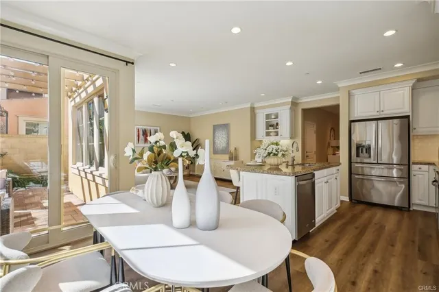 a kitchen with a dining table chairs and refrigerator
