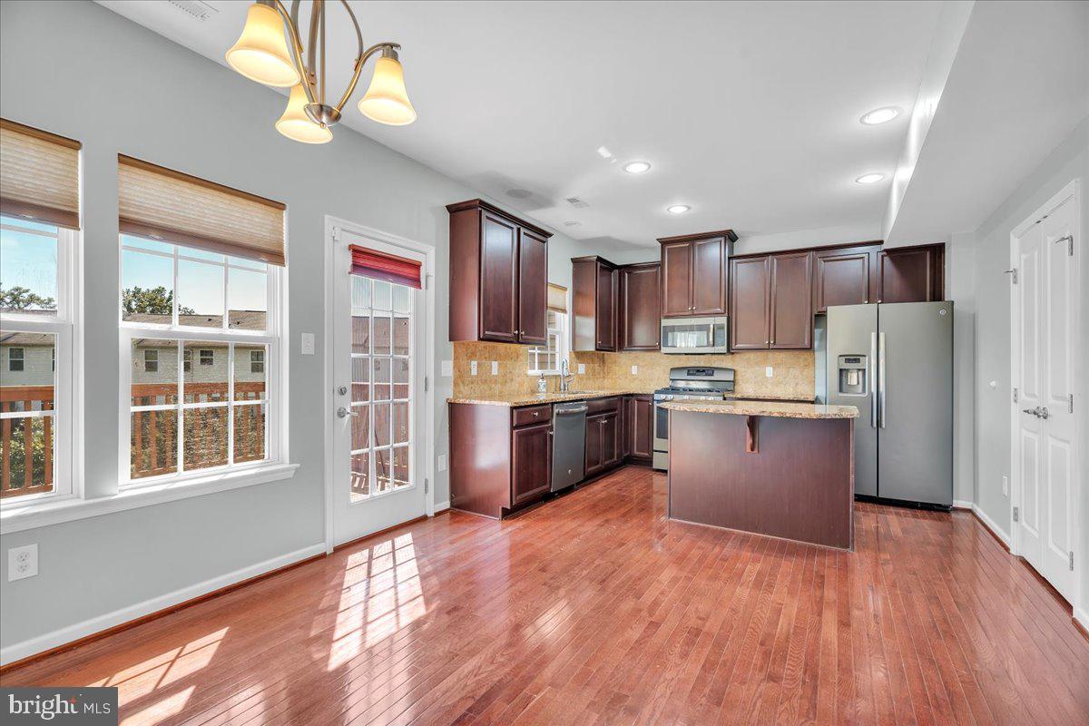 34 Wallace Road Mount Holly, NJ 08060 - Photo 7 of 28 a large kitchen with stainless steel appliances granite countertop a stove a refrigerator a sink dishwasher a dining table and chairs with wooden floor