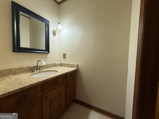 a bathroom with a granite countertop sink and a mirror