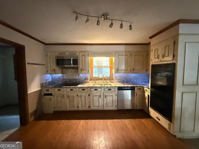 a kitchen with granite countertop a refrigerator stove and sink