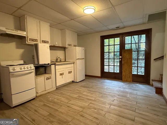 a kitchen with white cabinets and white appliances