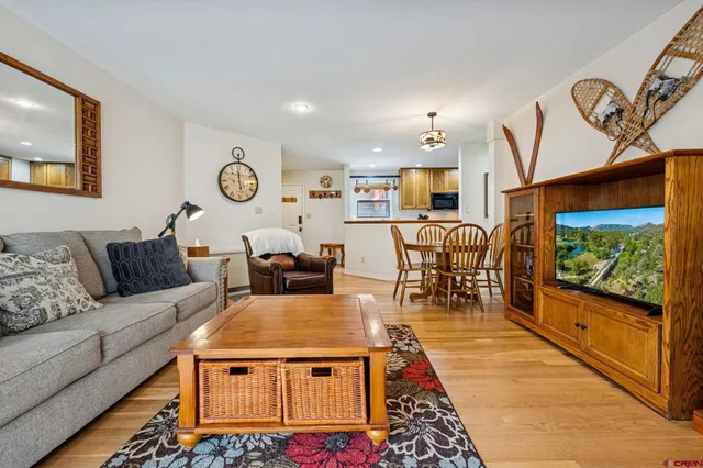 a living room with furniture a rug and a flat screen tv
