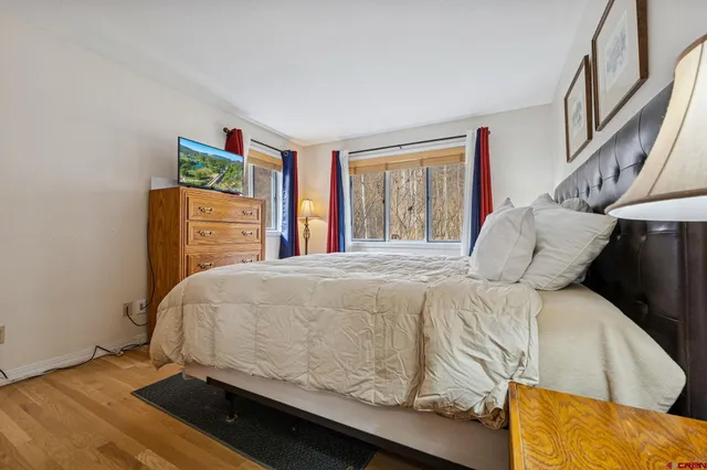 a bedroom with a bed and wooden floor