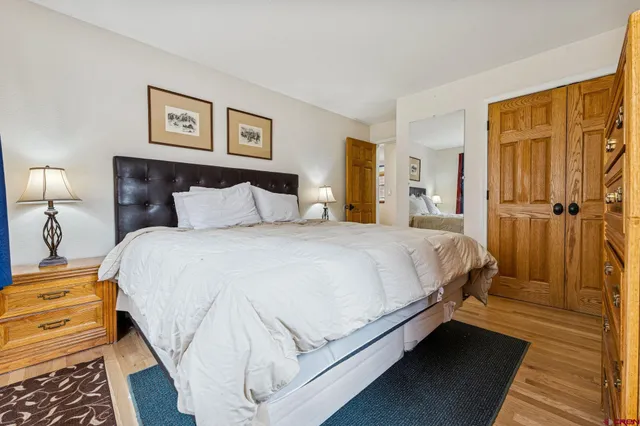 a bedroom with a bed and painting on the wall