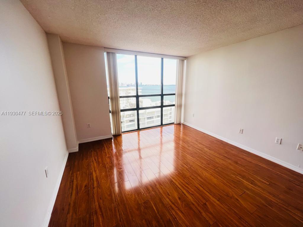 1450 Brickell Bay Drive, Unit 1606 Miami, FL 33131 - Photo 16 of 39 wooden floor in an empty room with a window