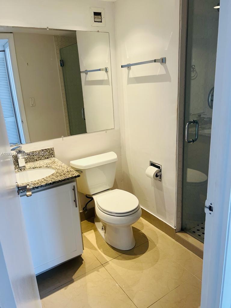 1450 Brickell Bay Drive, Unit 1606 Miami, FL 33131 - Photo 18 of 39 a bathroom with a granite countertop sink toilet and shower