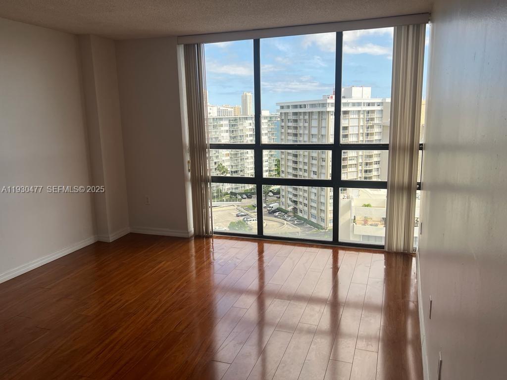 1450 Brickell Bay Drive, Unit 1606 Miami, FL 33131 - Photo 20 of 39 a view of an empty room with wooden floor and a window