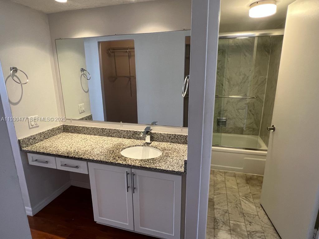 1450 Brickell Bay Drive, Unit 1606 Miami, FL 33131 - Photo 23 of 39 a bathroom with a granite countertop sink and a mirror