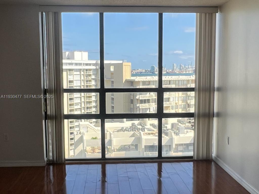 1450 Brickell Bay Drive, Unit 1606 Miami, FL 33131 - Photo 24 of 39 a view of an empty room with wooden floor and windows