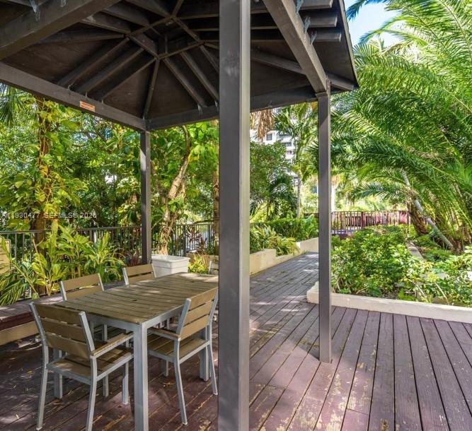 1450 Brickell Bay Drive, Unit 1606 Miami, FL 33131 - Photo 38 of 39 a view of a patio with table and chairs under an umbrella with a small yard