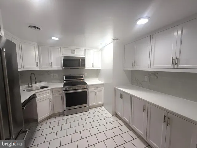 a kitchen with a stove sink and cabinets